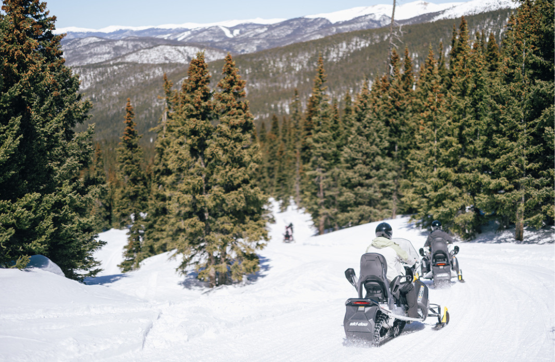 Family enjoying a snowmobile tour with Good Times Adventures at the top of Georgia Pass in Breckenridge, Colorado.